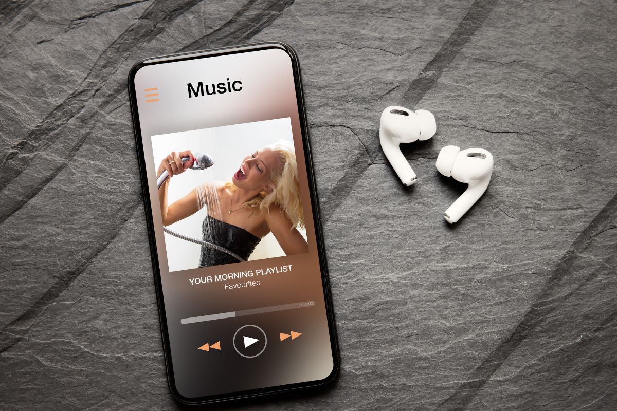 The image tells about a pair of earphones and a phone with a screen display referring to making a playlist that motivates you and keeps your mind and goals in front of you.