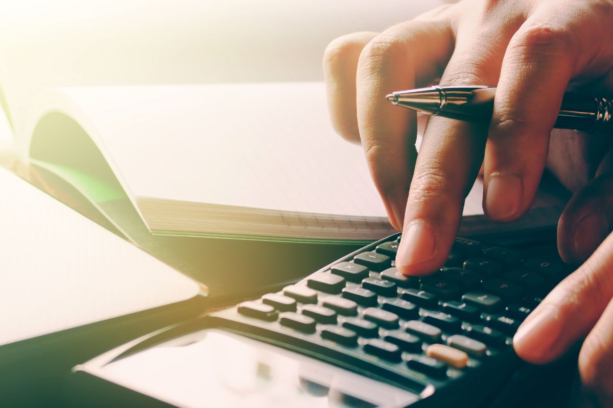 The picture shows a woman's hand making a budget.