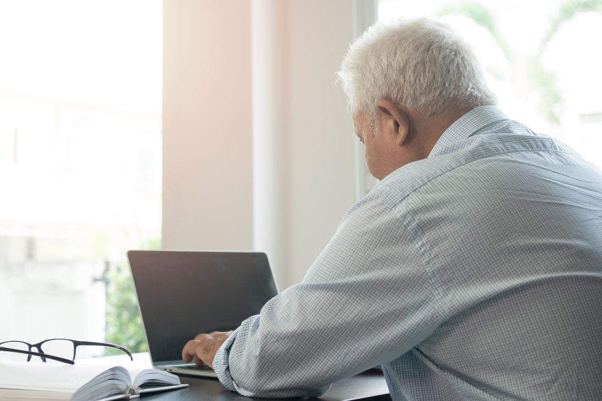 The image of a senior man using a laptop.