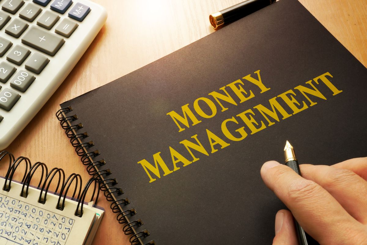 The image shows a man's hand with a money management book.