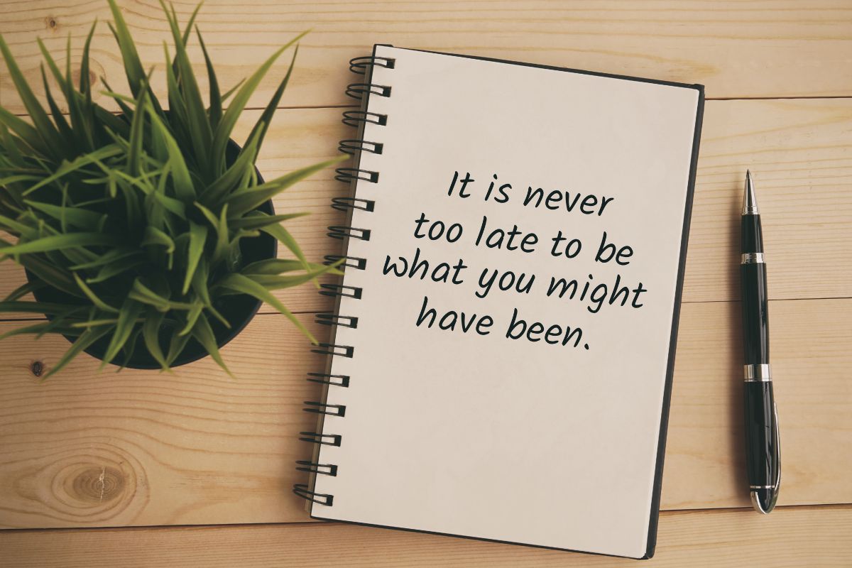 The image shows a pen and a notebook with a quote.