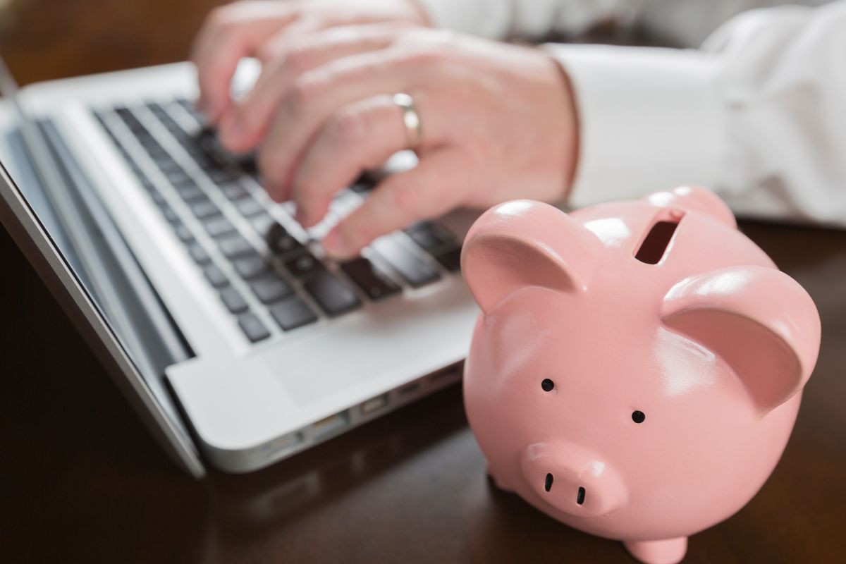 The photo shows a man's hand learning how to save money.