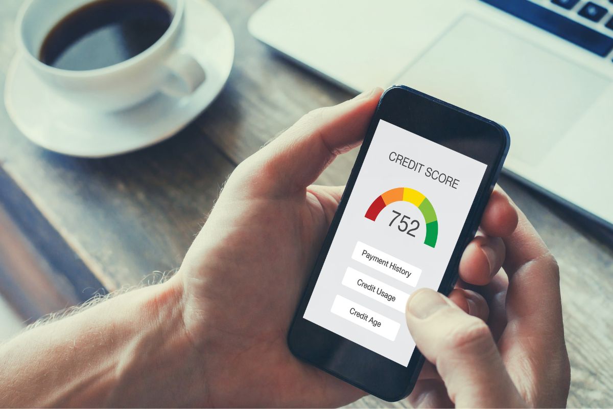 The photo shows a man's hand using a phone for a credit score log.