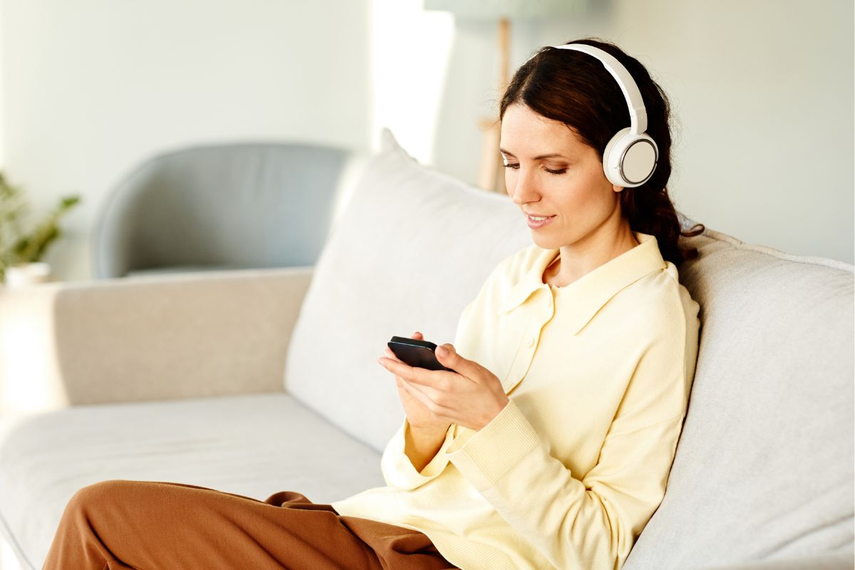 The picture shows a woman making a debt-free playlist.