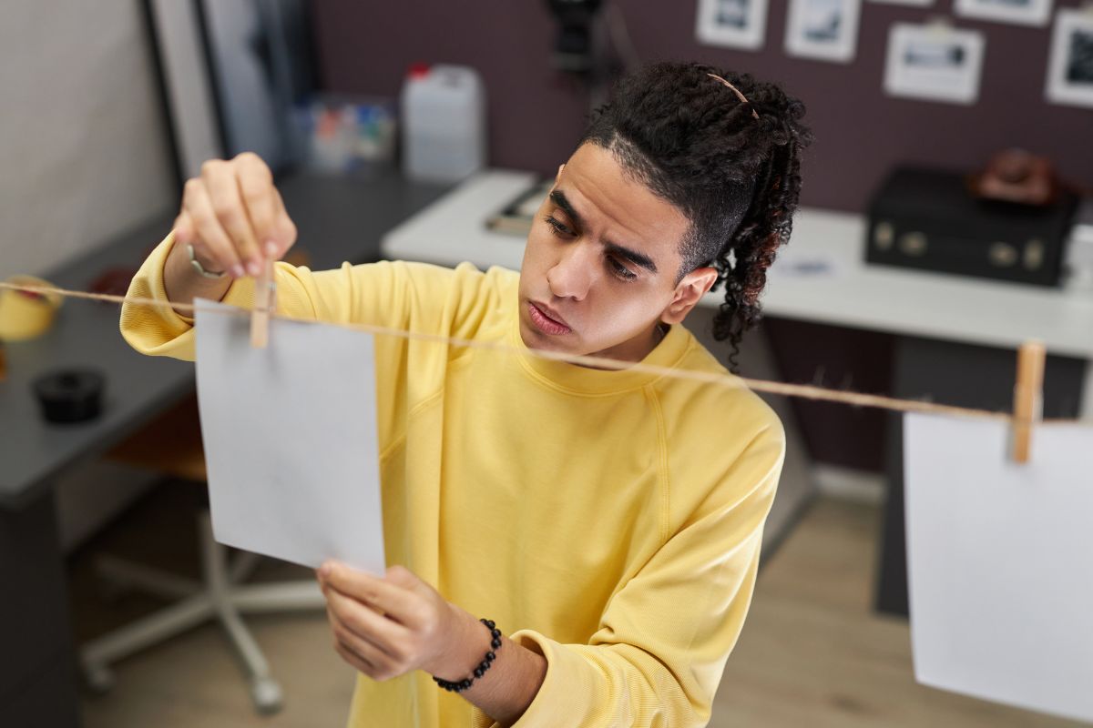 The photo shows a young man printing a photo.