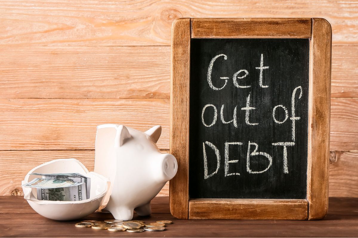 The picture shows a board with get out of debt wording.