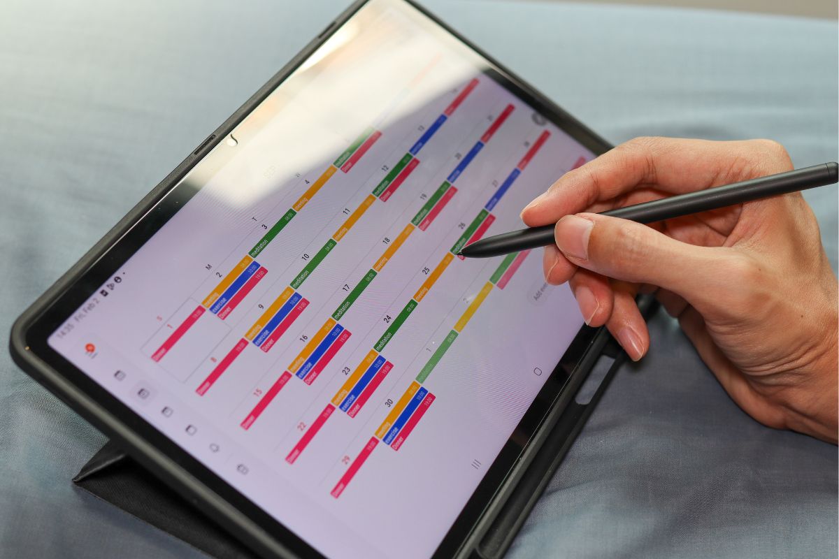 The photo shows a man's hand making schedules.