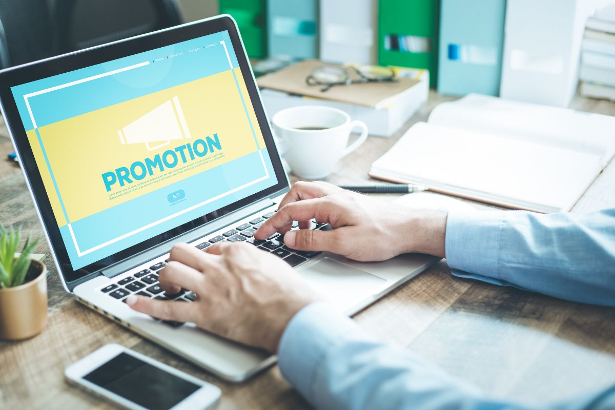 The photo shows a man's hand creating a short promotion plan.