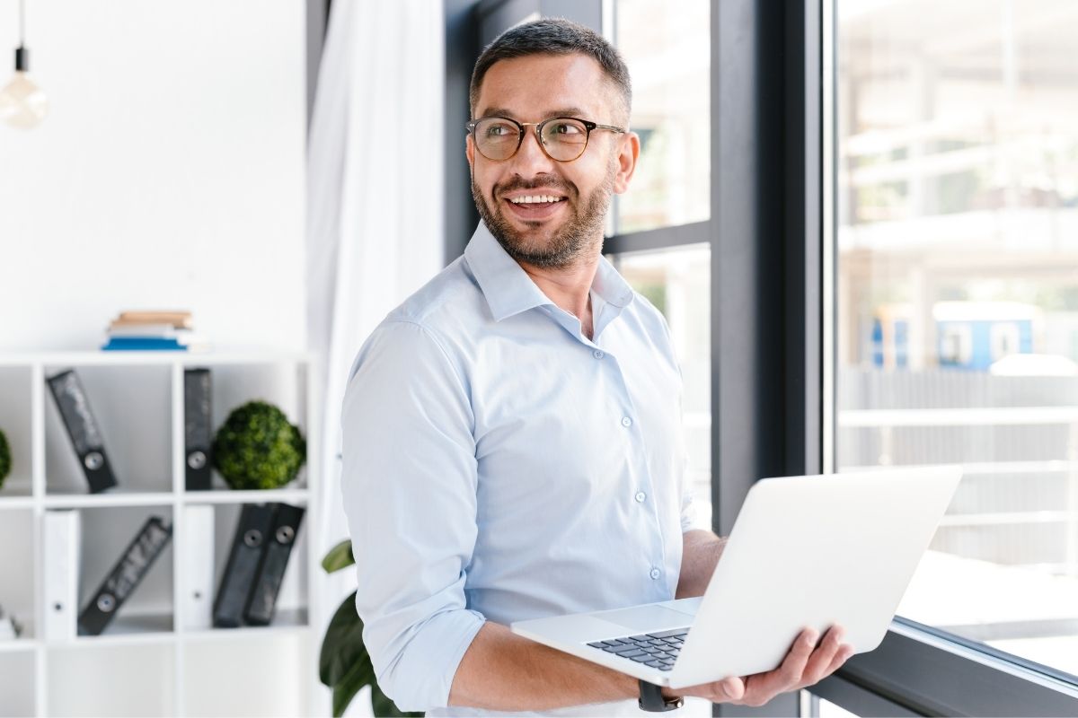 The image shows a man carrying a laptop.