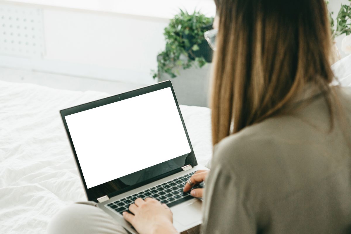 The photo shows a lady using a laptop for a brokerage platform.