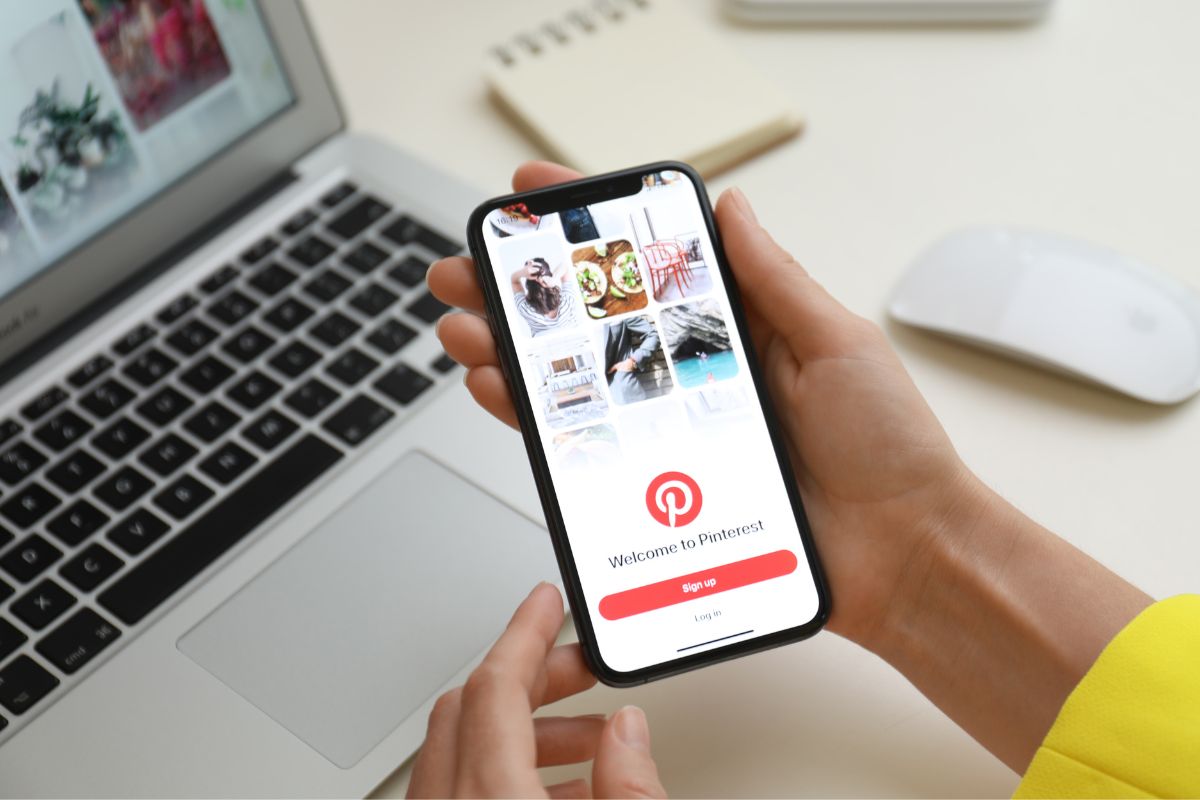 The image shows a woman's hand working as a Pinterest manager.