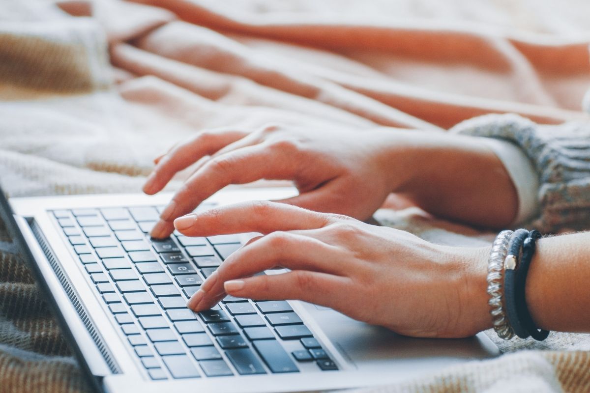 The photo shows a woman's hand wording as freelance writer.