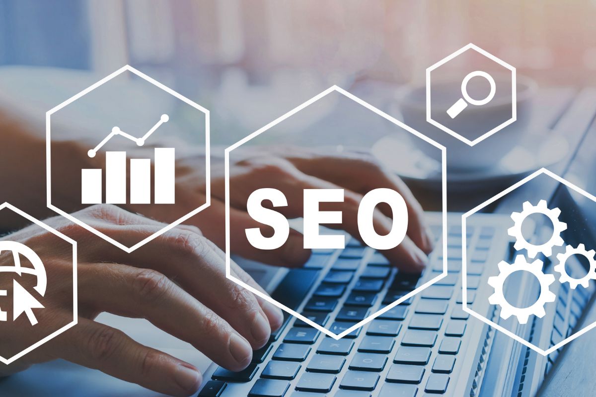 The picture of a man's hand using a laptop for SEO work.