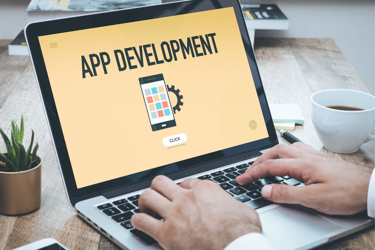 The image is about a man using a laptop for app development.