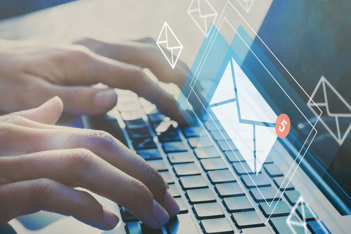 The photo is about a man's hand using a laptop for email marketing.