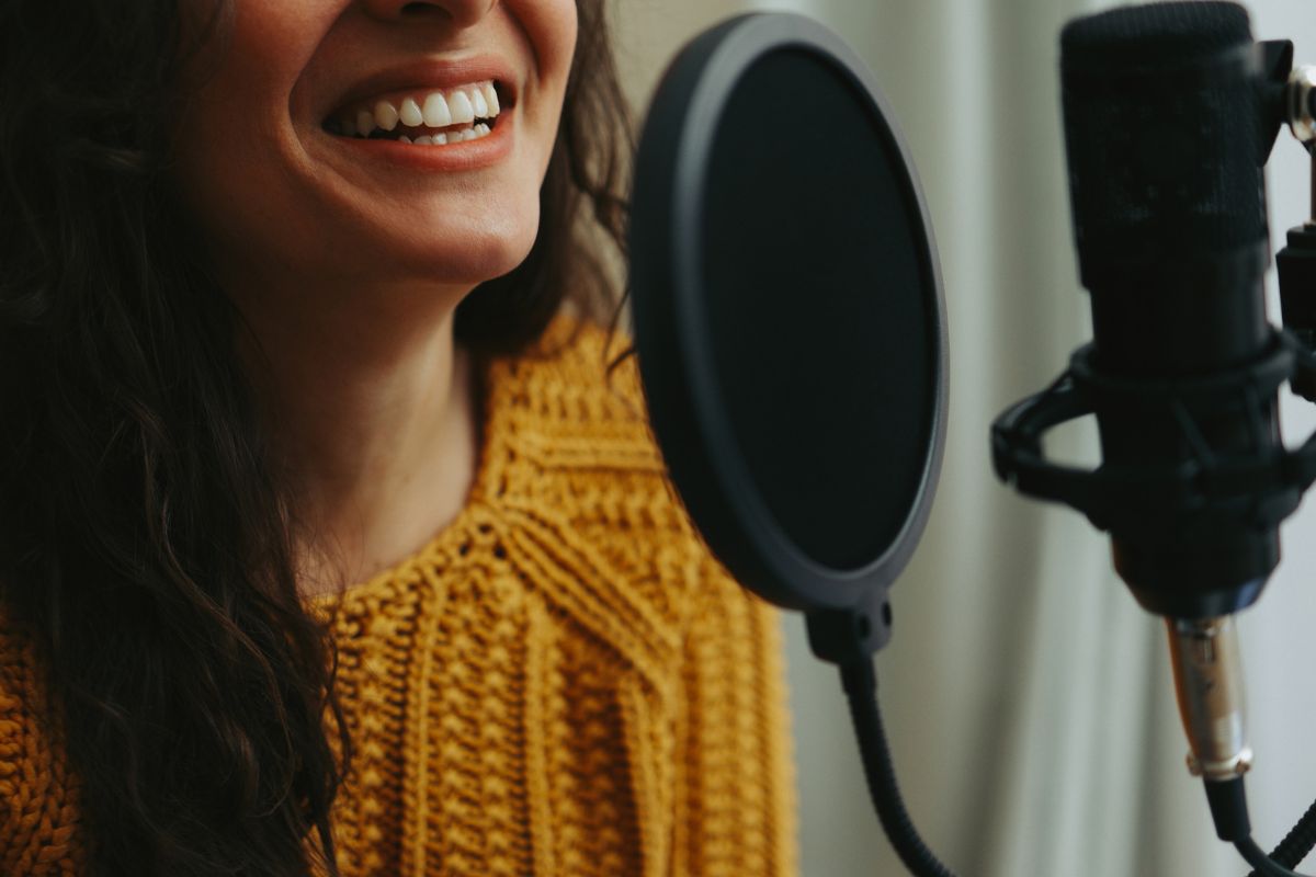 The image is about a young lady working as a voiceover artist.