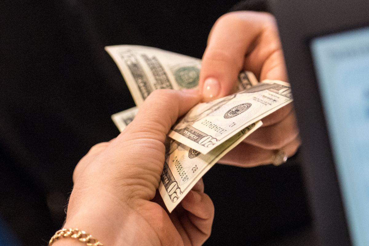 The picture shows a woman's hand using a cash for fun spending.