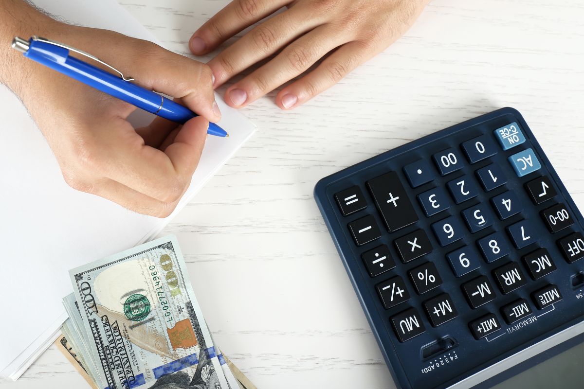 The image is about a man's hand splitting his paycheck.