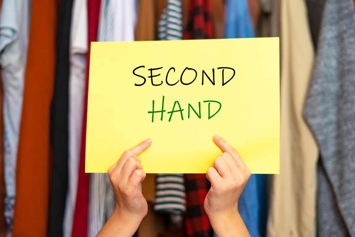 The image is about a lady's hand holding a paper with a second-hand note.