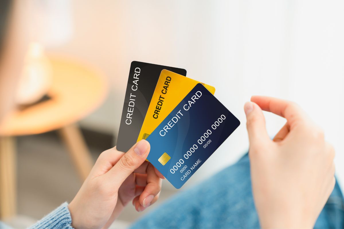 The photo is of a woman's hand holding credit cards.
