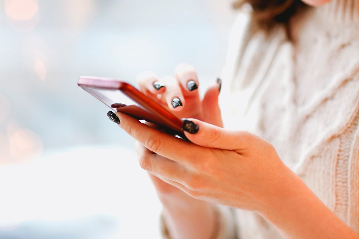 The photo shows a woman using library apps for books.