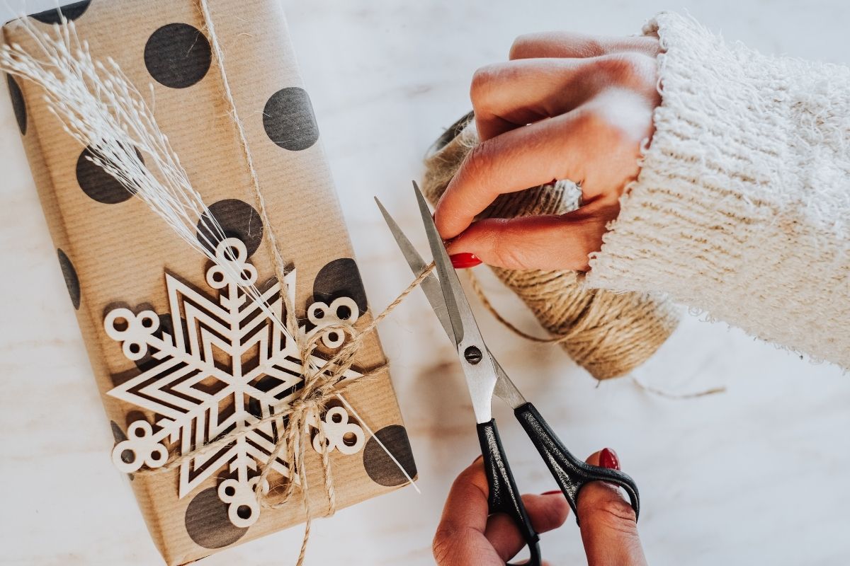 The picture shows a woman's hand making DIY gifts.