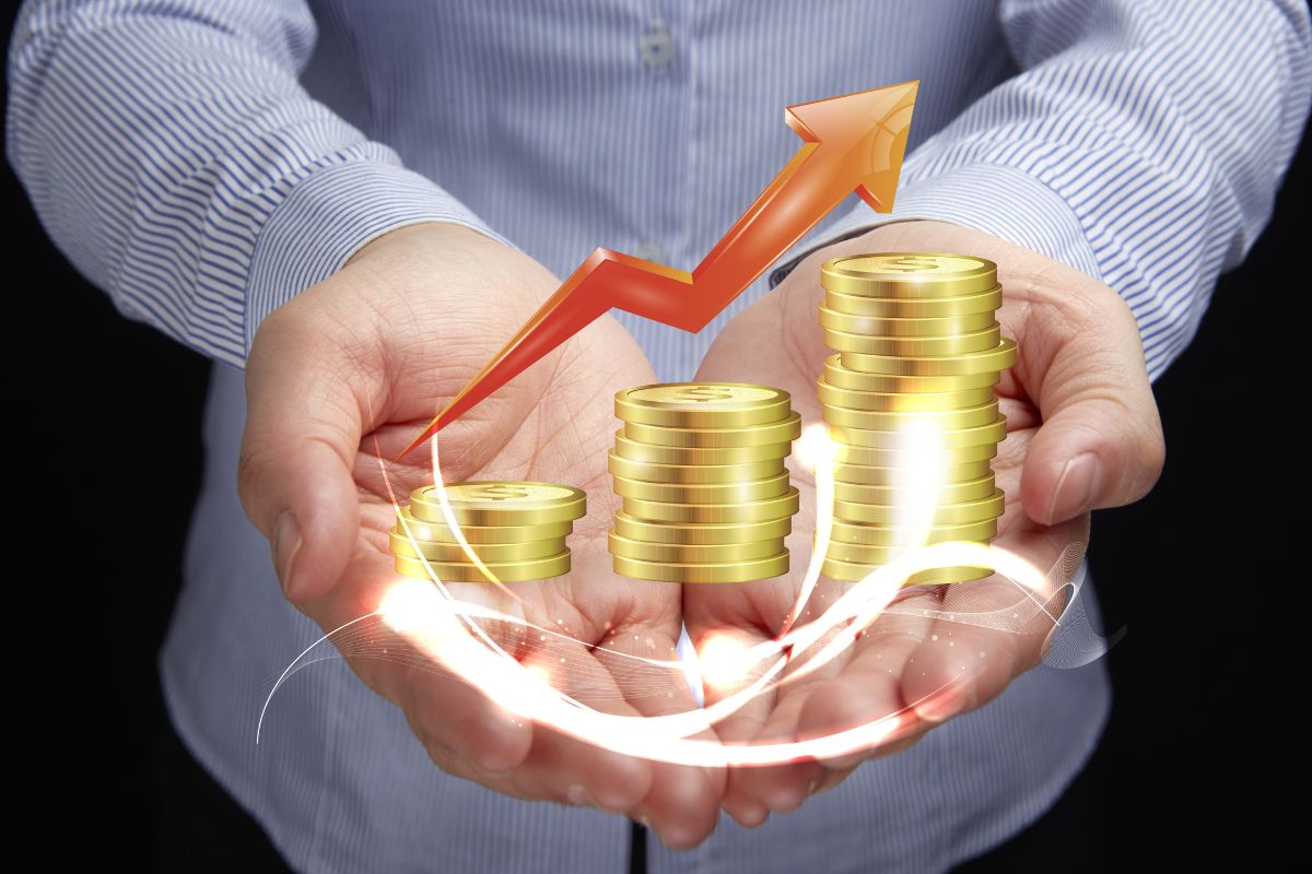 The picture shows a man's hand with coins to reinvest profits.