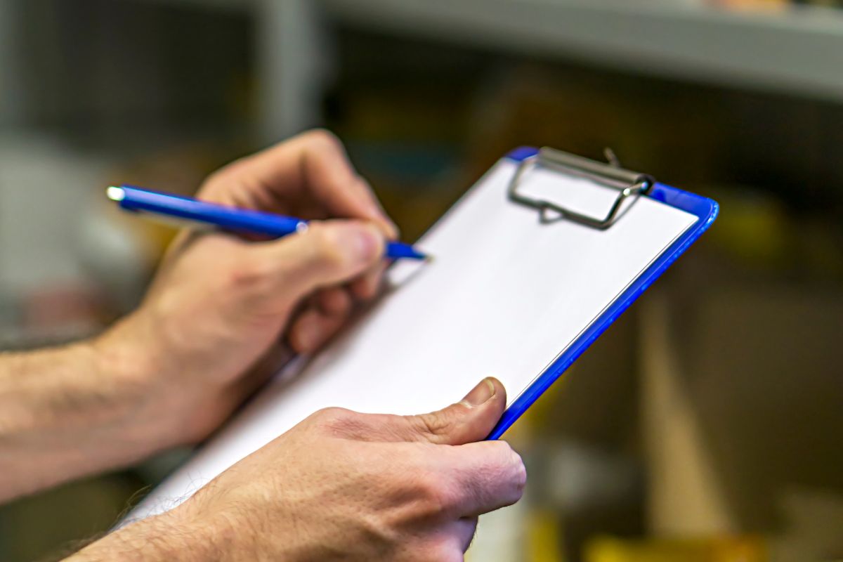 The picture shows a man's hand taking inventory of food in the pantry.