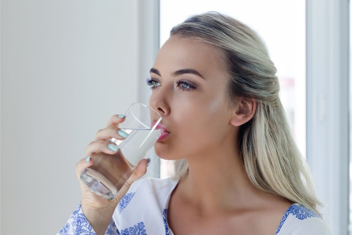 The image is about a woman drinking water.