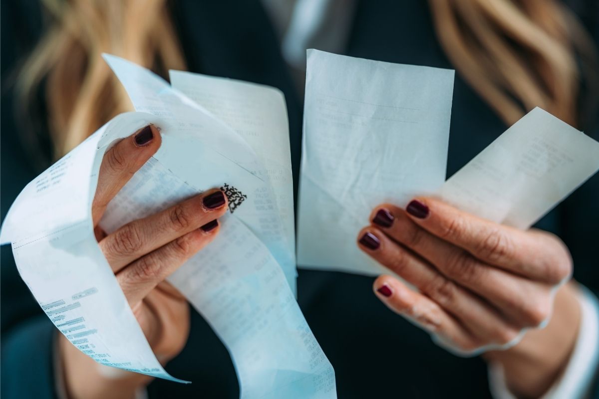 The picture shows a woman tracking receipts.