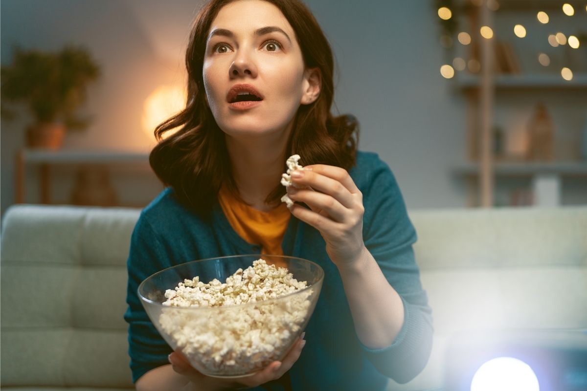 The picture shows a young lady watching a movie for a free reward.