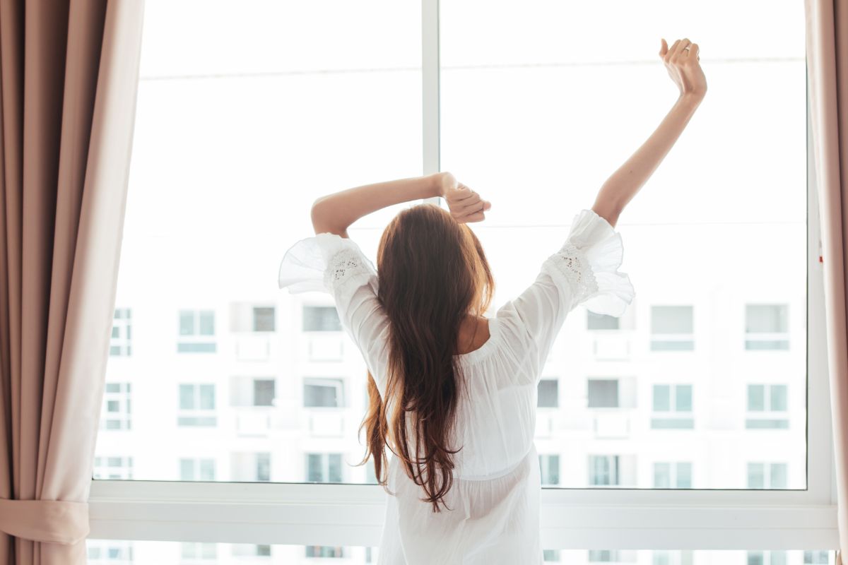 The picture shows a woman waking up early.