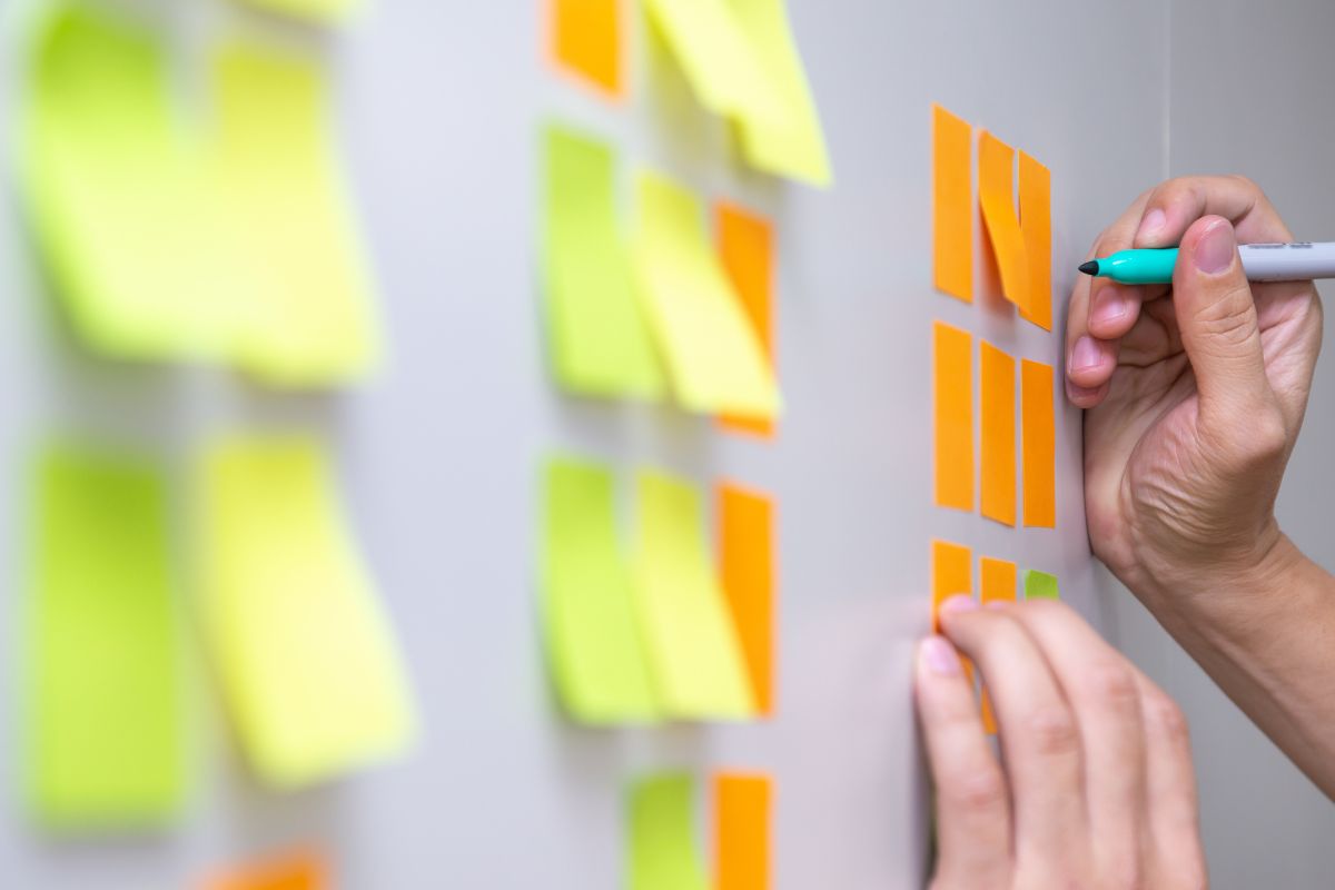 The photo shows a man's hand focusing on high-value tasks.