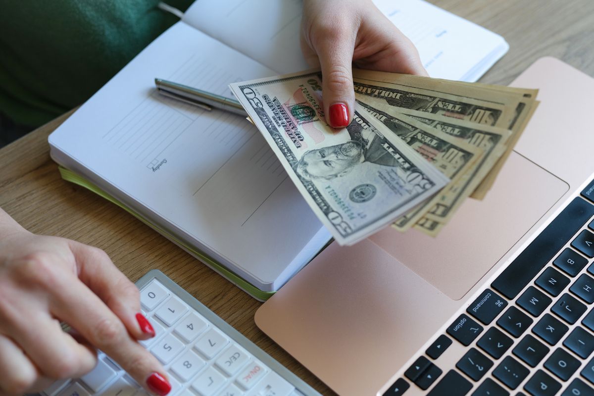 The picture shows a woman's hand assigning money hours.