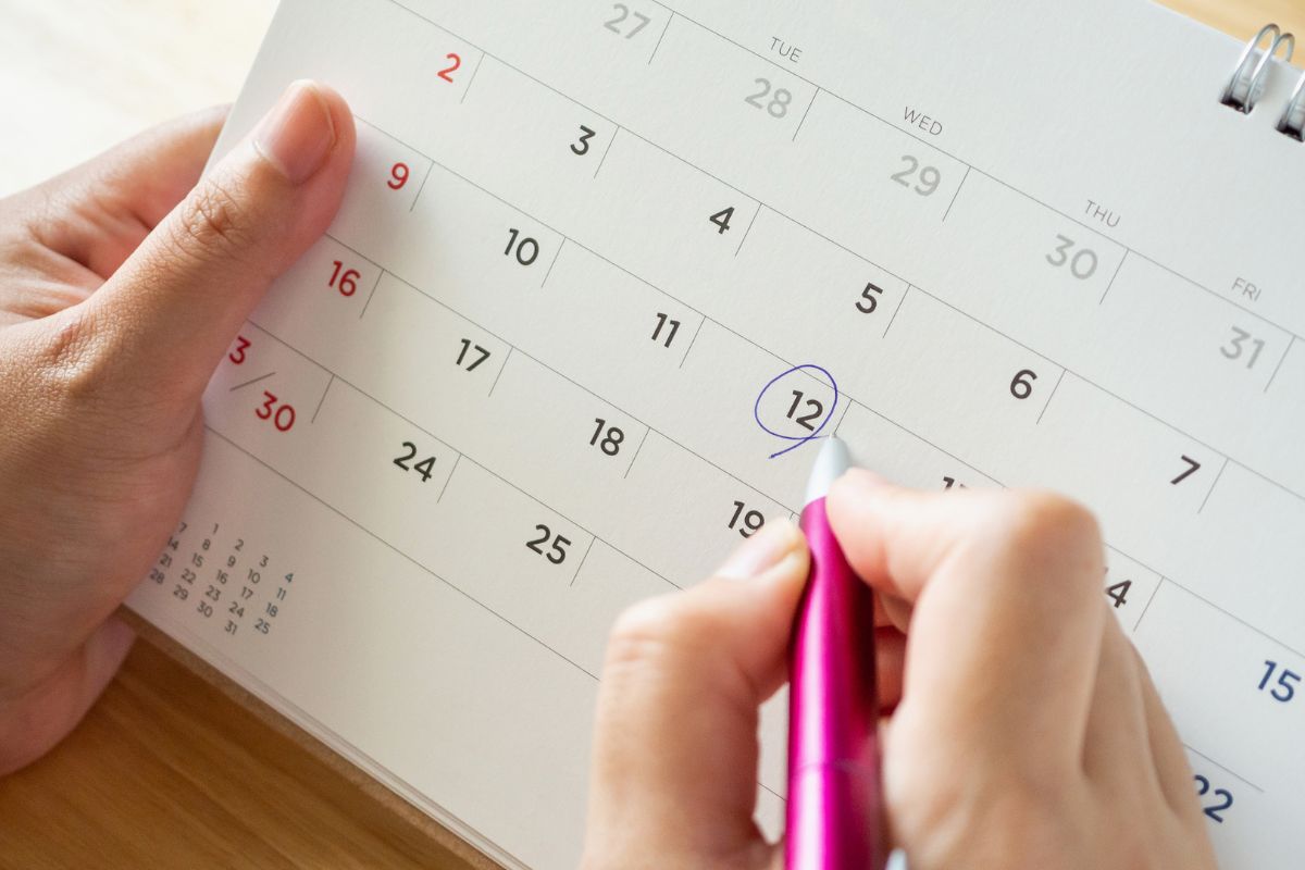 The photo is about a woman's hand treating a calendar like a bank.
