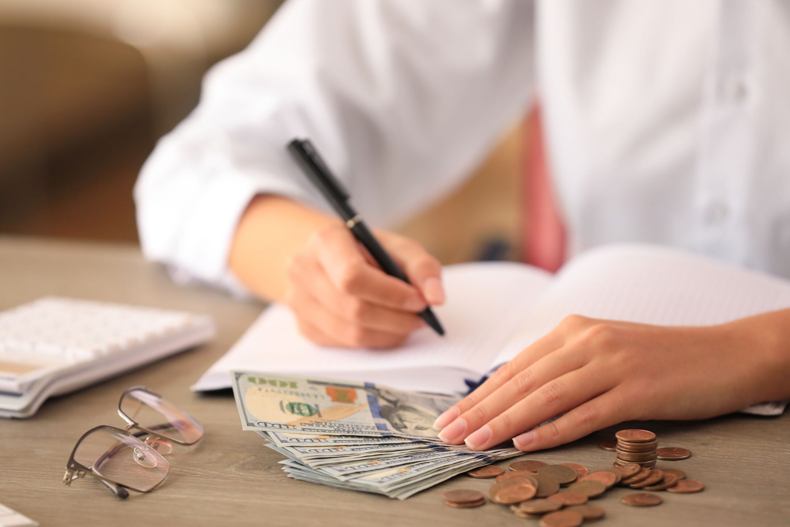 The photo shows a lady's hand setting a clear financial goal.