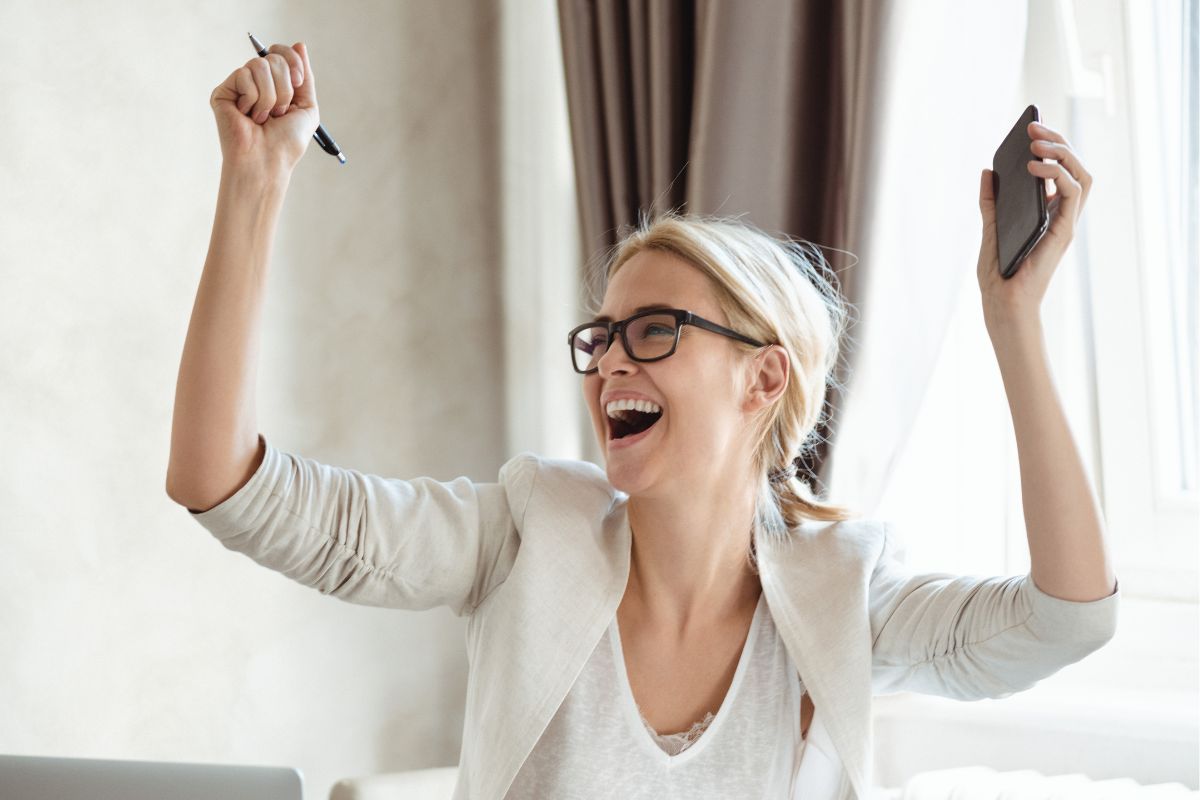 The picture shows a woman cheering and celebrating small wins.