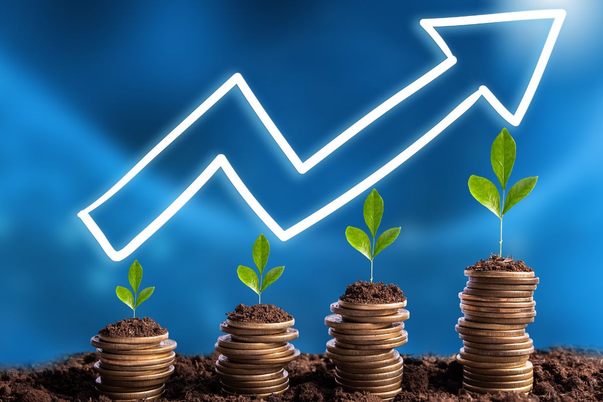 The photo shows coins with an arrow for the financial progress concept.