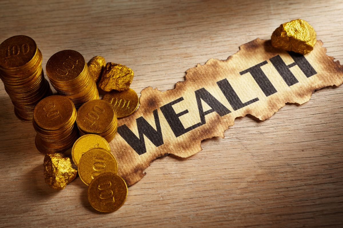 The image shows coins and paper with a wealth wording.