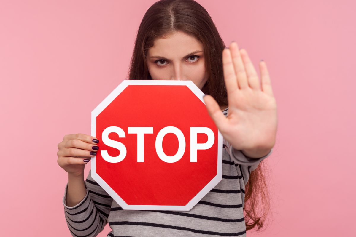 The photo shows a girl holding a stop sign.