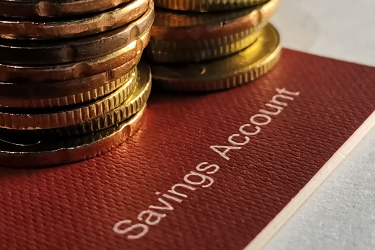 The photo shows coins and a savings account.