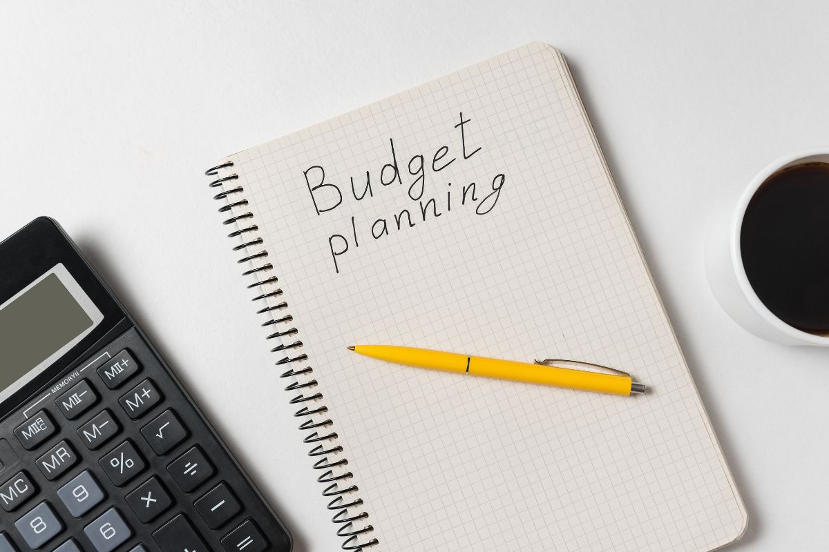 The image shows a notebook with a budget planning concept.