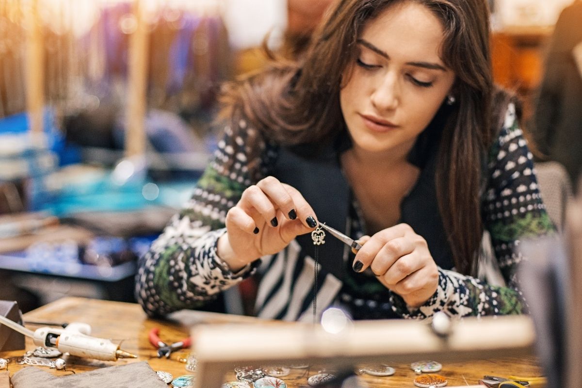 The picture shows a woman making homemade items to sell.