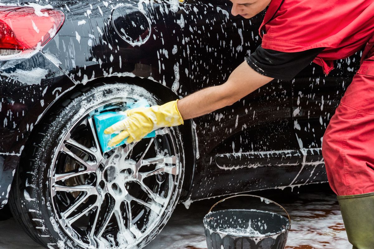 The photo of a man washing the car.