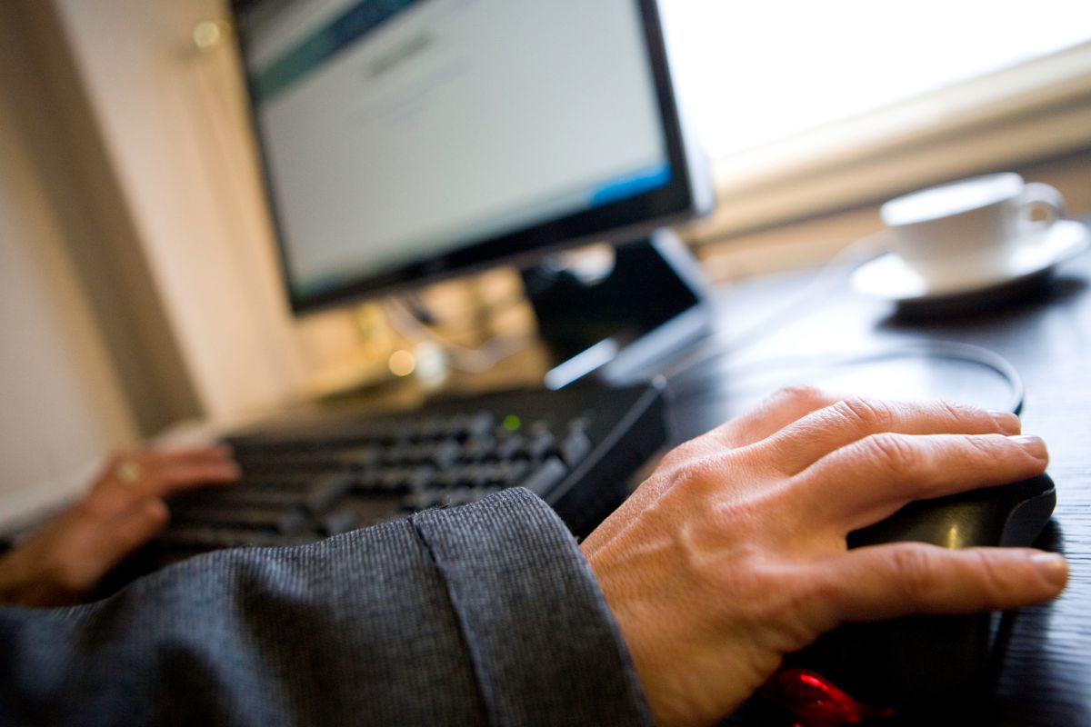 The photo of a man's hand providing tech help for others.