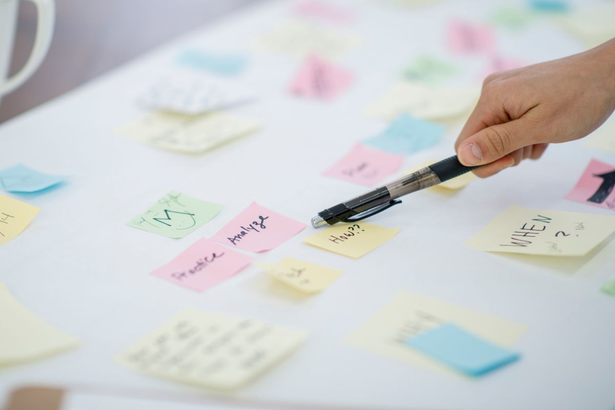 The image shows a lady's hand taking a look at her vision board.