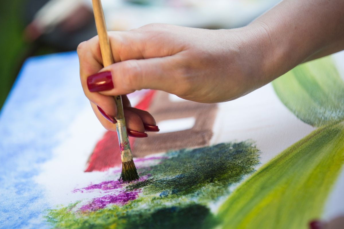 The picture shows a lady's hand turning her hobbies into a side gig.