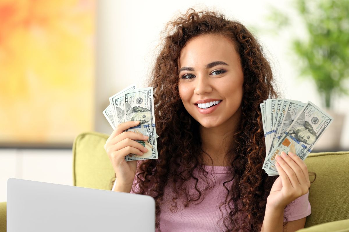 The photo of a woman holding dollar bills by Make Money Online.
