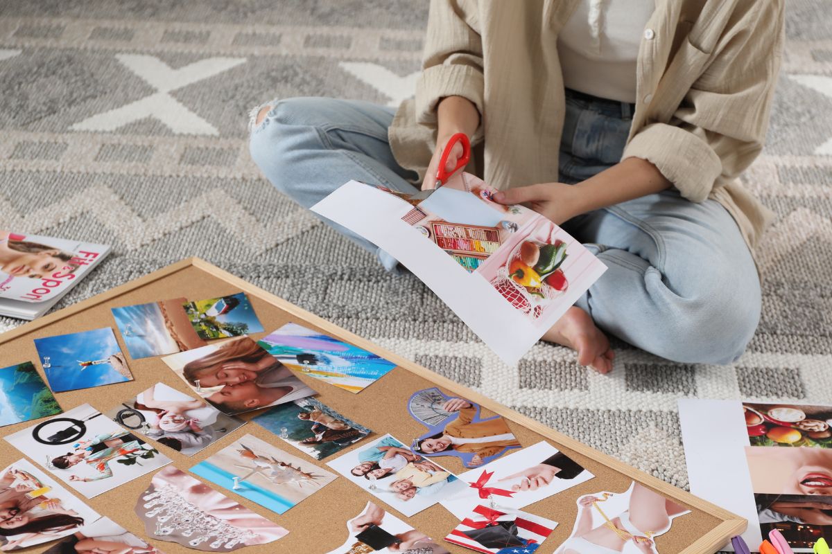 The picture shows a woman updating her vision board with new goals.