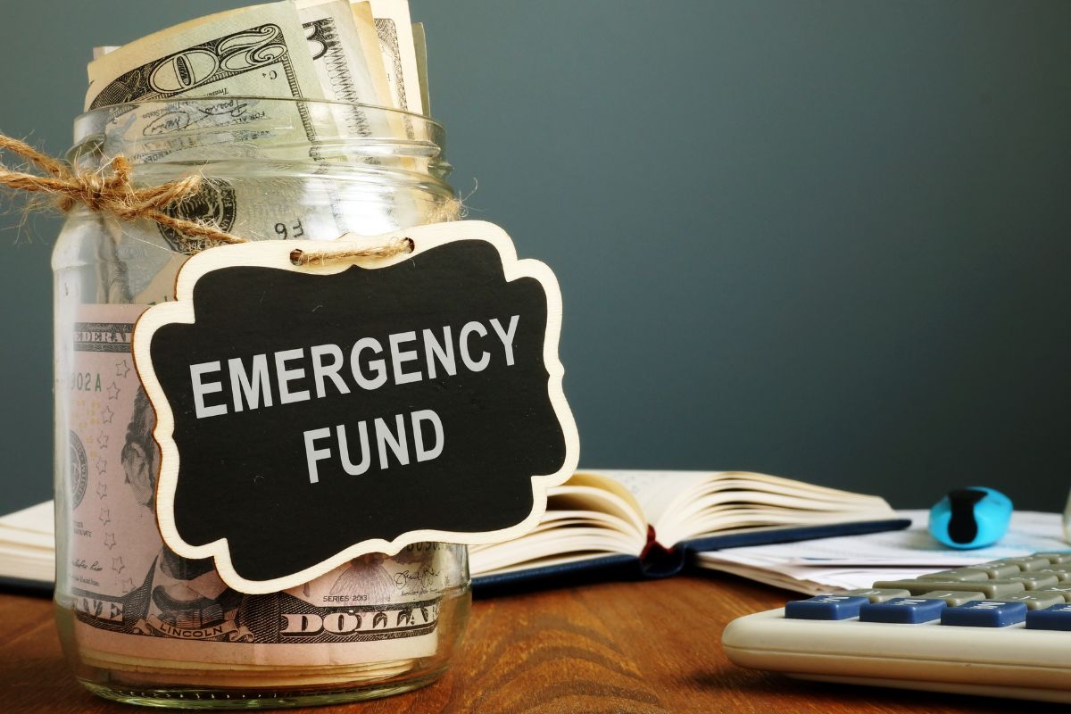 The photo shows a jar with dollar bills and an emergency fund note.